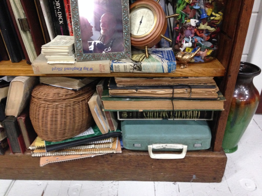 This writer's room is virtually devoid of electronic or mechanical writing equipment, save for this portable typewriter tucked under a stack of books.